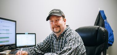 Ein Mensch sitzt an einem Arbeitsplatz vor dem Computer.