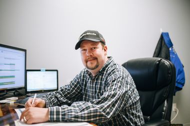 Ein Mensch sitzt an einem Arbeitsplatz vor dem Computer.