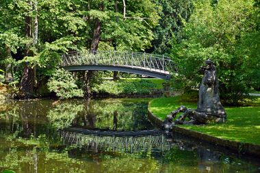 Brücke über den Kanal im Hofgarten Bayreuth, ringsum grüne Vegetation.