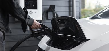 Ein Mensch lädt ein Elektro Auto.