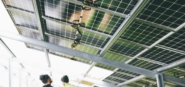 Blick von unten auf die Verkabelung von Solarmodulen in einem Solarpark.