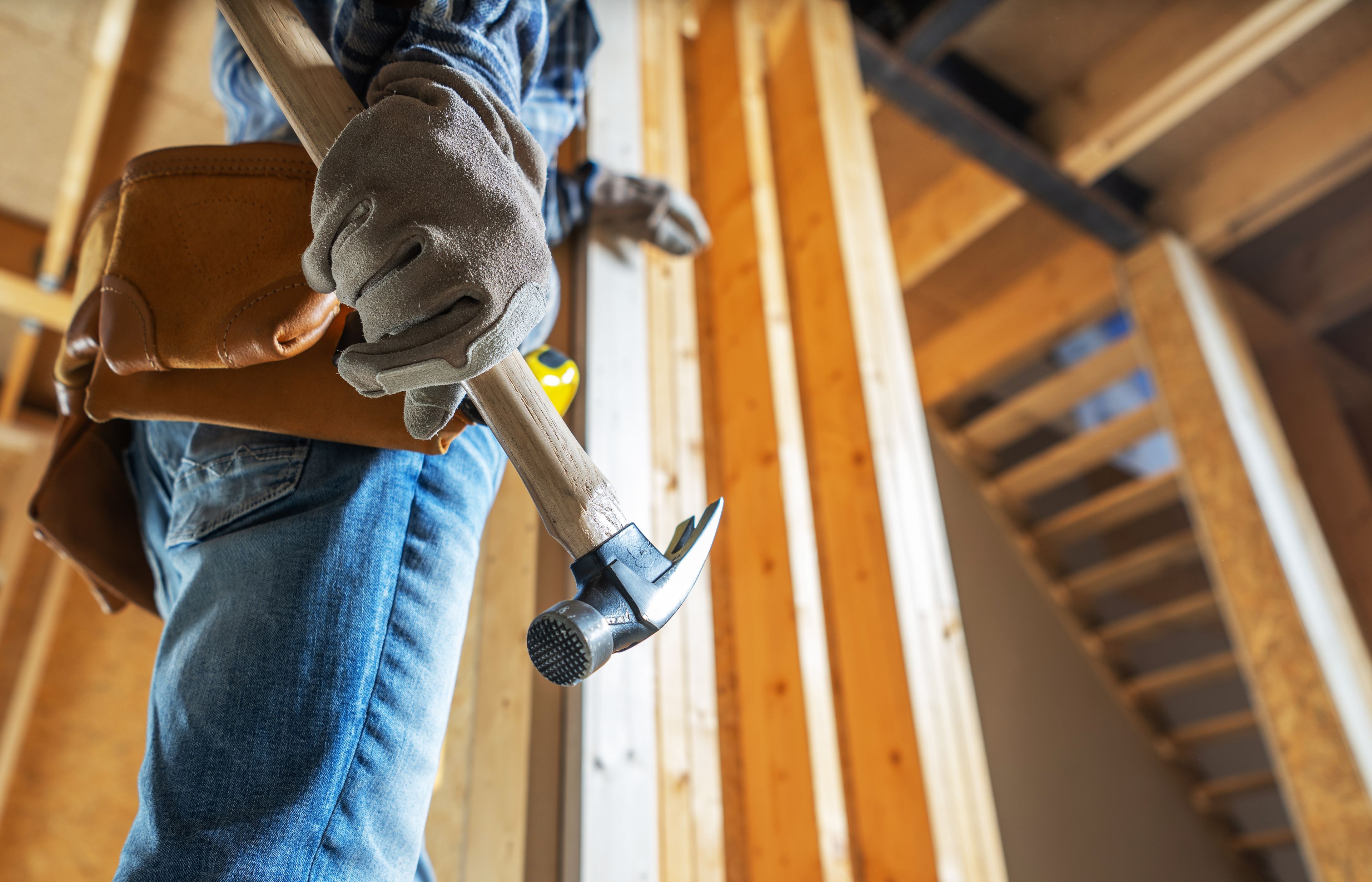 Construction worker holding hammer in unfinished home