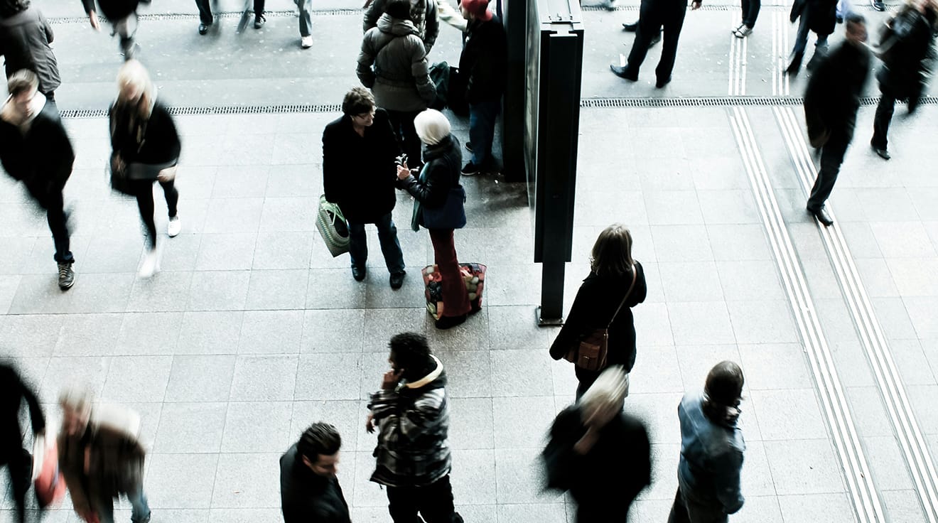 Människor i rörelse på ett torg.