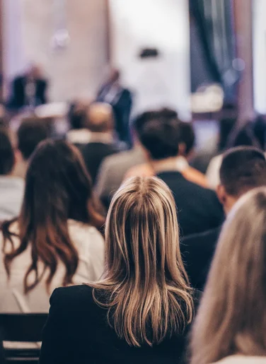 Teaserbild für eine Konferenz, das Publikum vor auf einer Konferenz zeigt