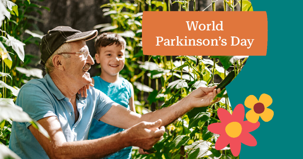 Elderly man and boy smiling in a garden, holding a phone. Text reads "World Parkinson's Day" with colorful flowers.