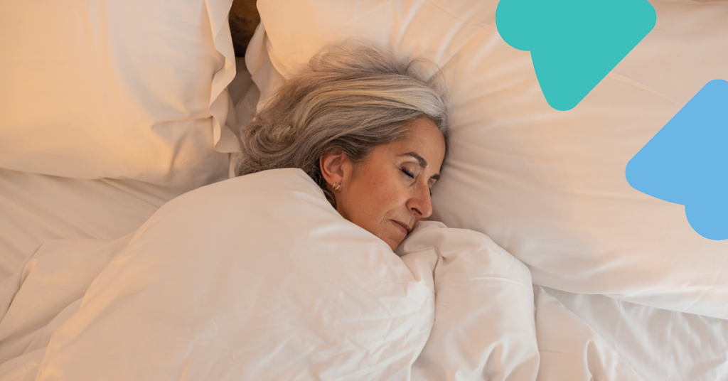 Woman with gray hair peacefully sleeping in a bed with white sheets and pillows, surrounded by soft lighting and abstract blue shapes.