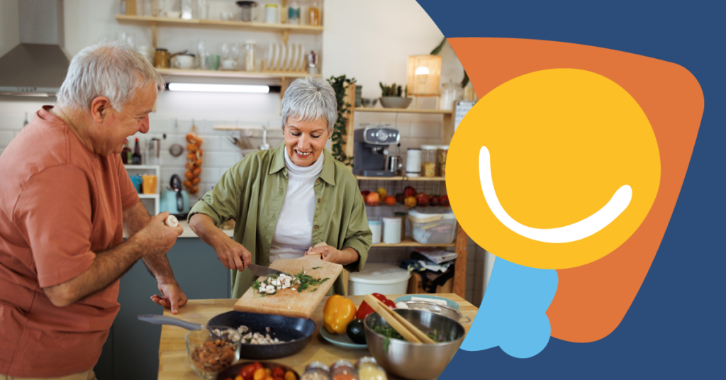 Elderly couple cooking together in a kitchen, smiling, with vegetables and utensils around. Colorful abstract graphic on the right.