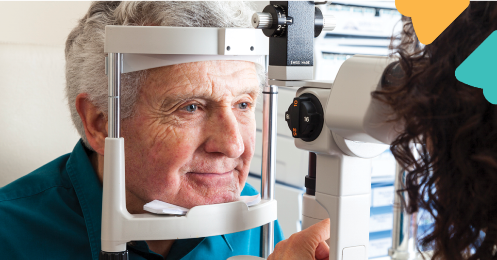 An elderly man undergoing an eye examination with a slit lamp, assisted by an optometrist in an eye clinic.