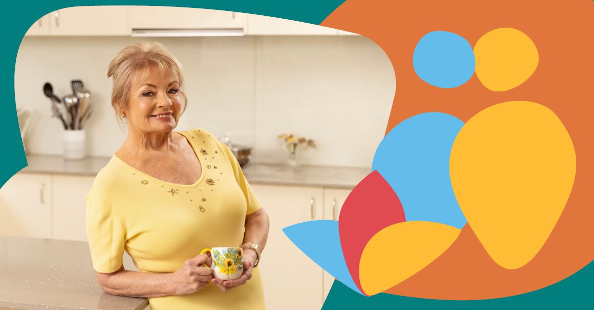 Smiling woman in a yellow shirt holds a mug in a kitchen, with colorful abstract shapes on the right.