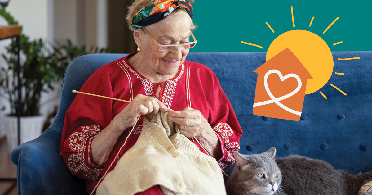 Elderly woman in a red dress knitting on a blue sofa, with a gray cat beside her and a sun and house graphic in the background.