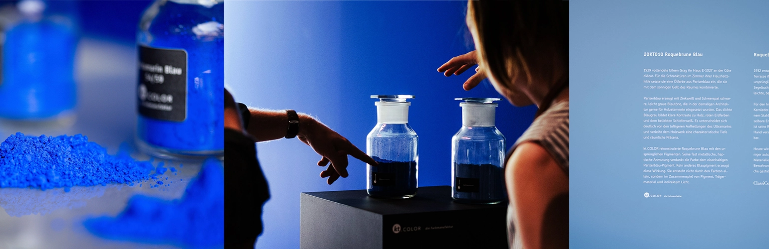 Two people interact with jars of blue pigment under a blue light, with descriptive text about the color and its significance on a wall nearby.