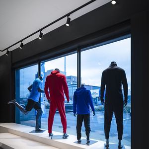 Schaufenster mit bekleideten Puppen von Schienen-Spots beleuchtet