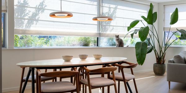Heller Essbereich mit zwei runden Pendelleuchten in Kupferoptik über einem Holztisch