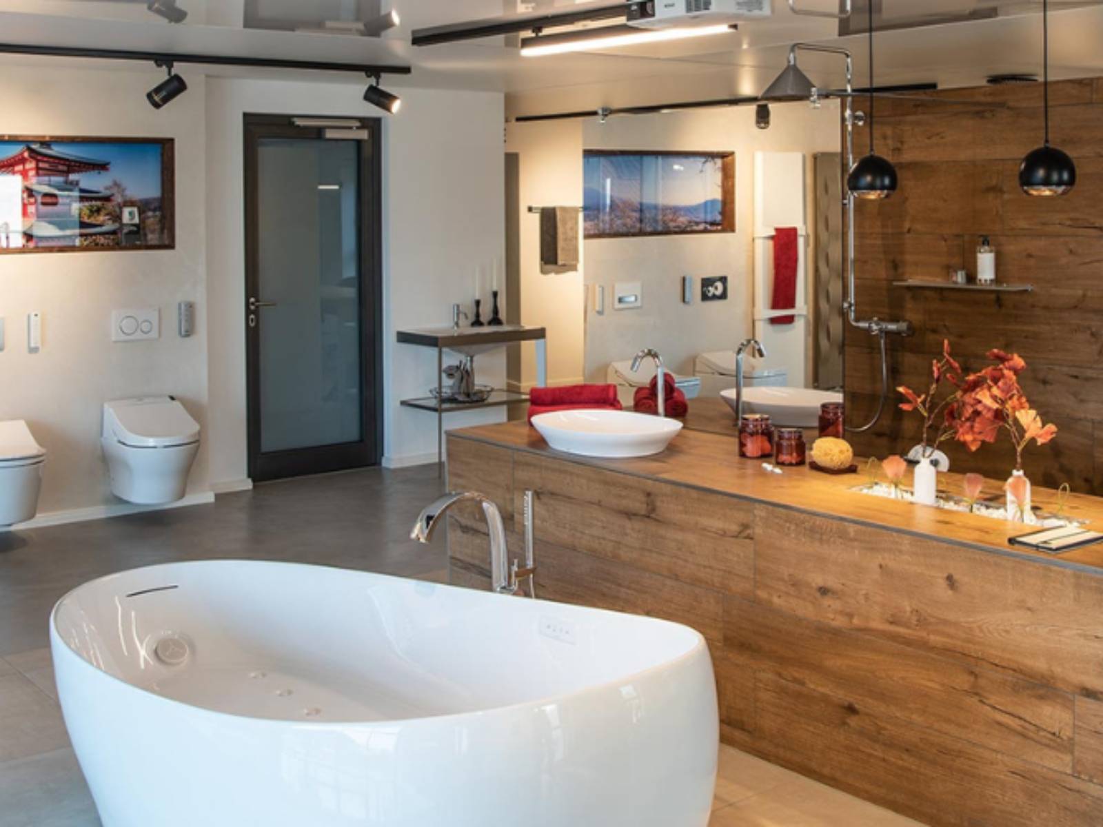 Exklusiver Showroom mit freistehender Badewanne, Holzverkleidungen und schwarzen Kugelleuchten über dem Waschtisch