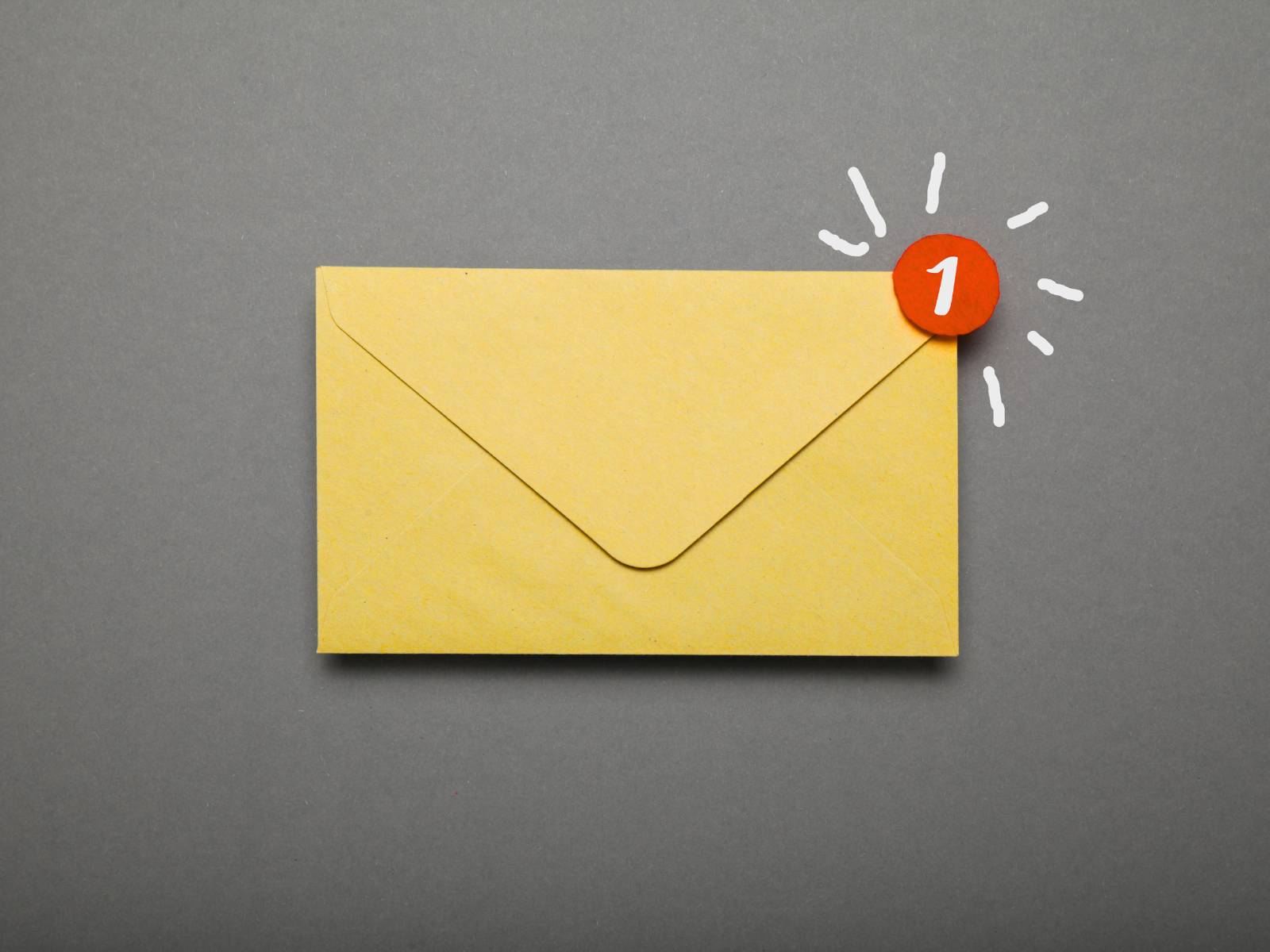 Gelber Briefumschlag auf grauem Hintergrund. Rechts oben ist ein kleiner roter Kreis mit einer weißen 1, der eine neue Mail anzeigen soll.