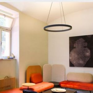 Moderner Raum mit bunten gepolsterten Sitzgelegenheiten, ONE CUBE Pendelleuchte, abstrakter Wandkunst und einem kleinen Fenster.