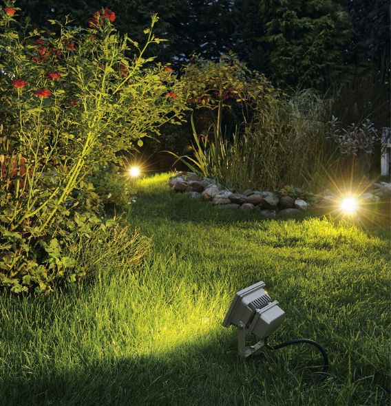 Erdspieß von SLV beleuchtet Busch mit Blumen in Garten.
