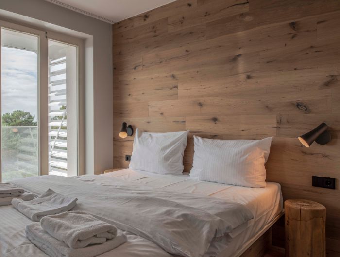 Ferienwohnung mit gemütlichem Doppelbett und SLV Bedside Beleuchtung.