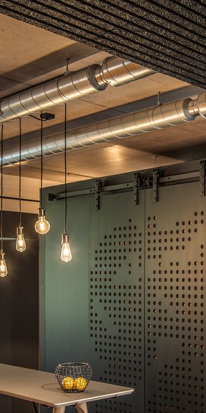 Pendelleuchten mit Filament Leuchtmittel in Glühbirnen-Optik über Bar-Tisch in Büroraum.
