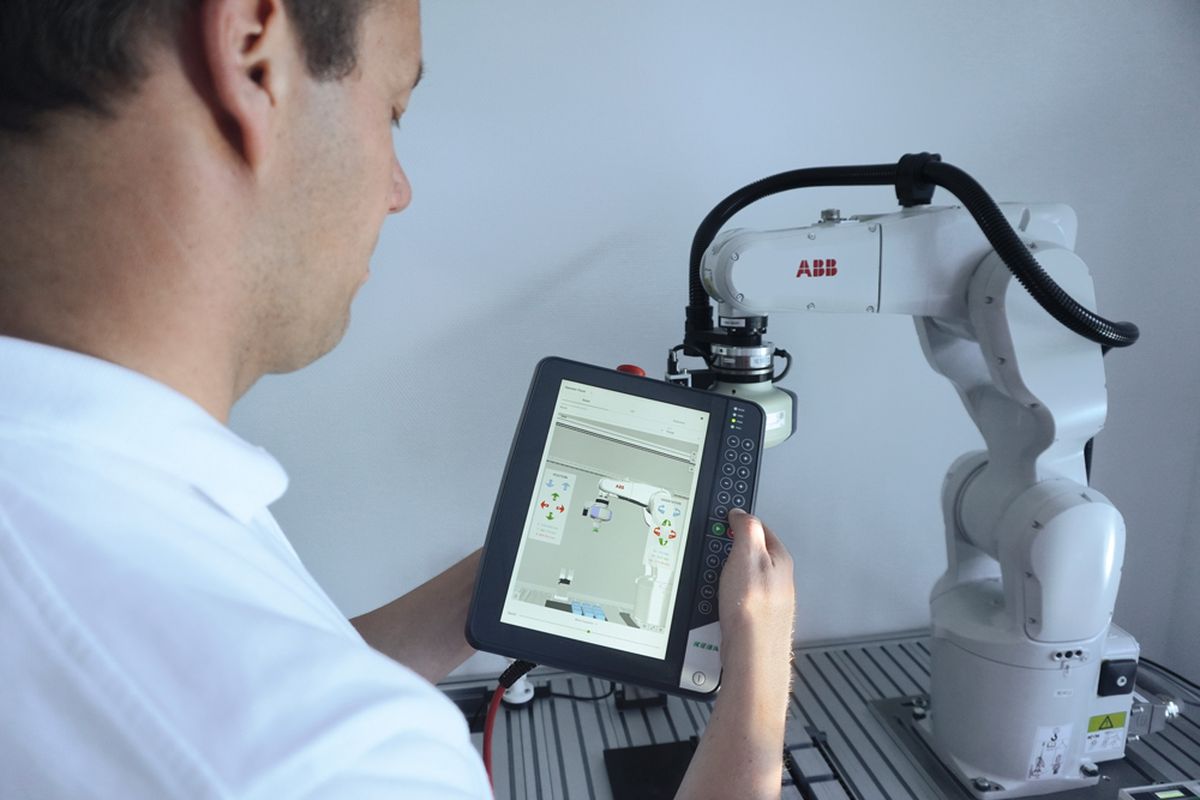 A man operates an ABB robot using a KEBA KeTop panel.