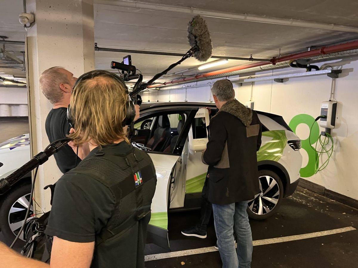 Kamerateam begleitet Christian Clerici beim Einsteigen in ein Elektrofahrzeug mit KEBA-Ladestation.