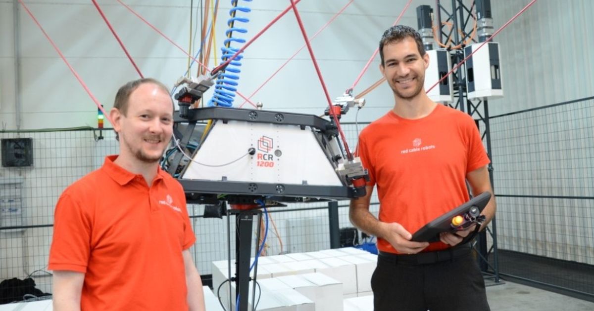 Qualitätskontrolle: Zwei Mitarbeitende in einer Fabrik inspizieren ein transparentes Kunststoffteil unter hellem Licht, mit Werkzeugen an einer Lochwand im Hintergrund.