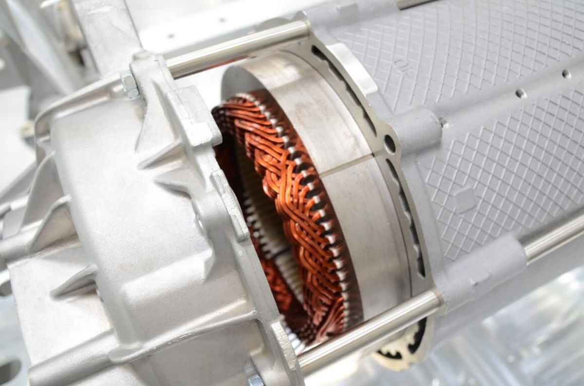 Open electric motor with visible copper windings and aluminum housing. The image represents energy efficiency, precision manufacturing, and advanced drive technology in industrial automation.