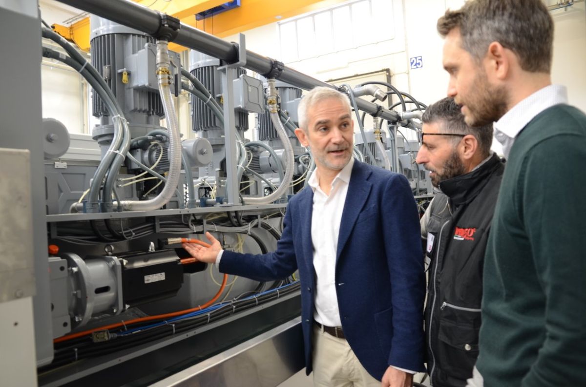 Luigi Franchini (KEBA) explains technical details of the KEBA drive solution on a Breton polishing machine to two other gentlemen.