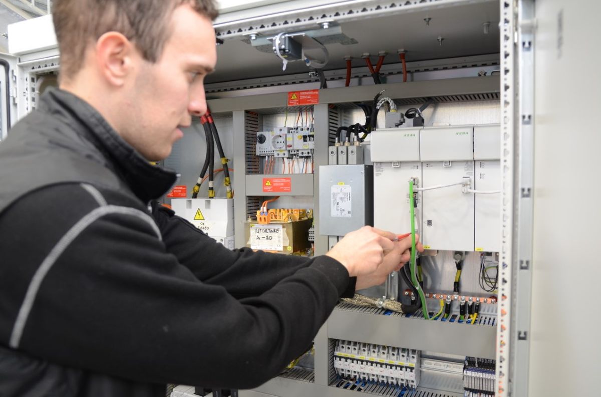 Technician works on the control cabinet of a Breton machine in which KEBA control technology is installed.