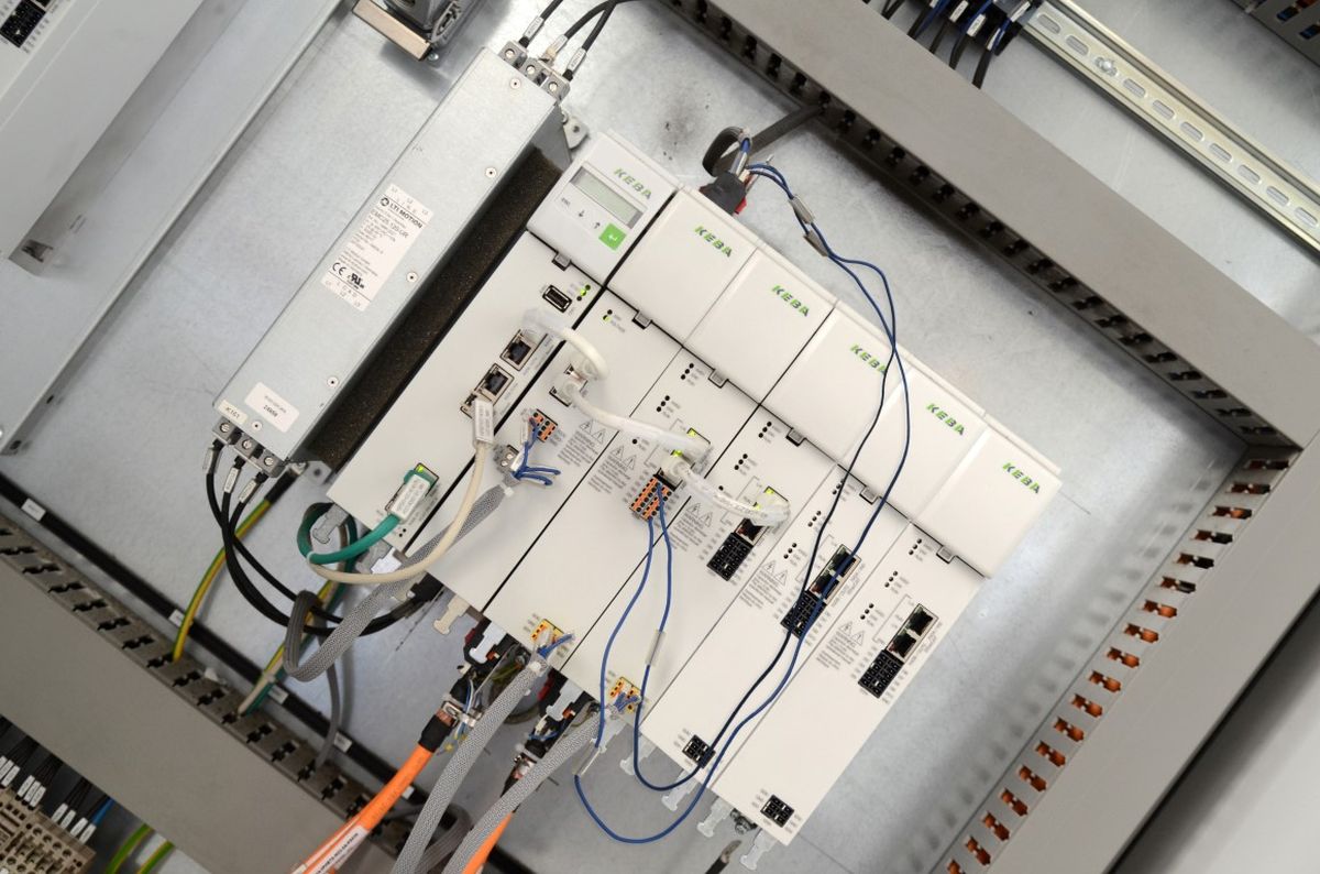 Vista all’interno di un quadro elettrico industriale con diversi moduli di controllo KEBA collegati tramite cavi dati e di alimentazione – simbolo di automazione precisa e tecnologia di controllo connessa.