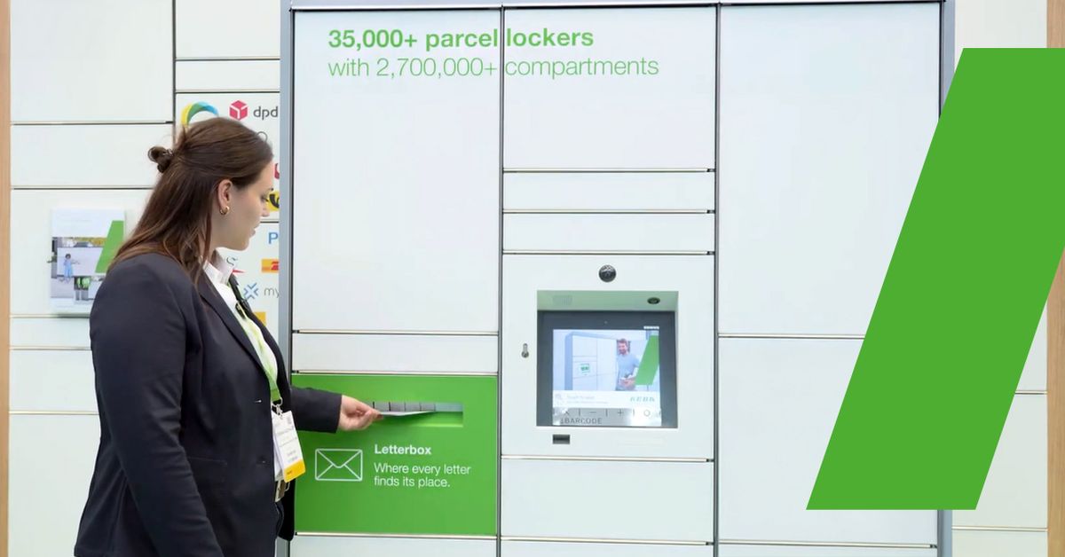 Eine Frau wirft einen Brief in den integrierten Briefschlitz der Paketstation ein.