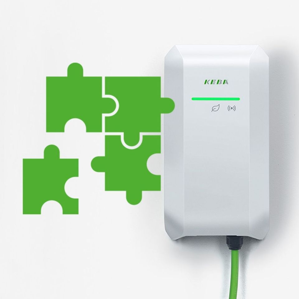 White KEBA KeContact P40 Company Car Wallbox next to green puzzle pieces, symbolising easy integration into existing systems.