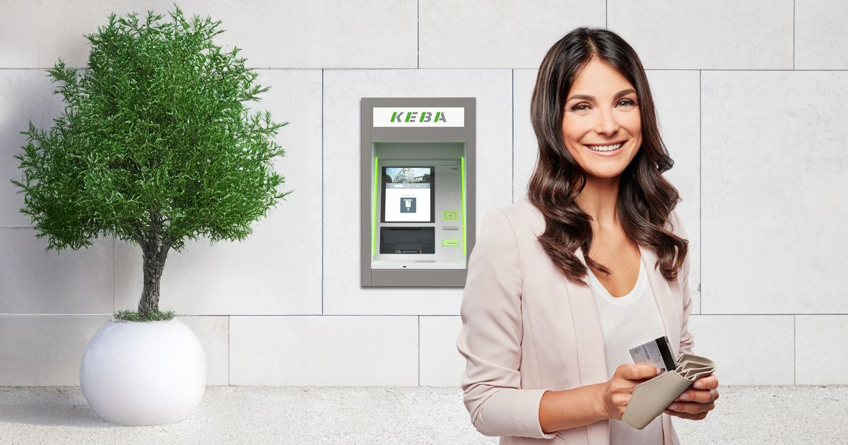 Smiling woman holding cards stands near a KEBA cash recycler, with a potted plant in the background.