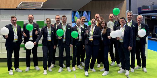 Ein Team von KEBA Mitarbeitenden mit grünen und weißen Luftballons auf der Parcel+Post Expo 2025.