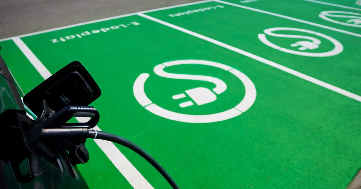 Öffentliche E-Ladeplätze und im Vordergrund ein Ladekabel im parkenden Auto angesteckt