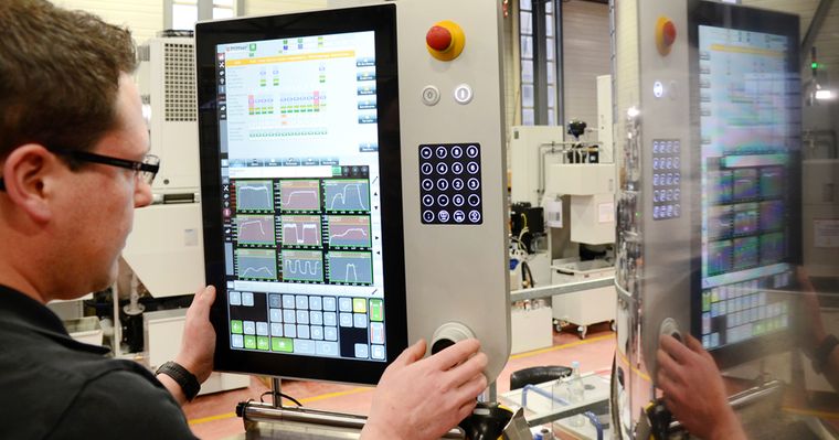 Darstellung eines Mitarbeiters von Pfiffner, der ein stationäres HMI bedient