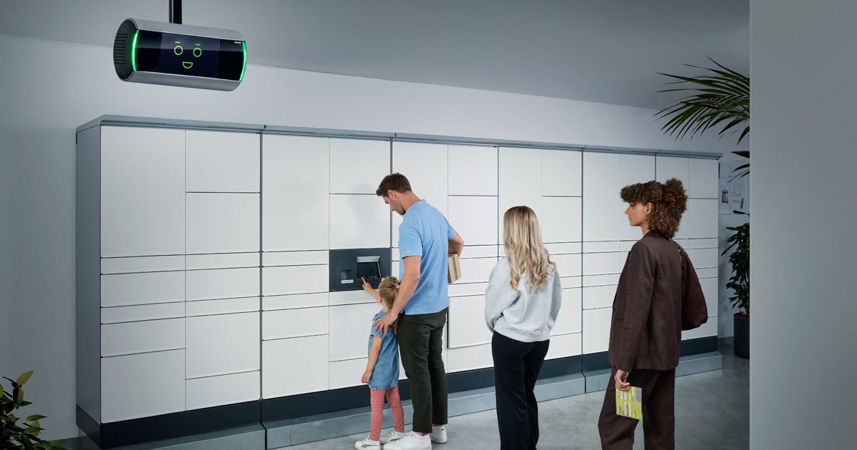 Moderne Bankfiliale mit Personen an Geldautomaten, KI-Assistent KeBob im Einsatz und Kunden beim Betreten durch Glastüren.