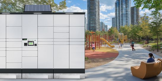 Moderne Parkszene mit solarbetriebener Paketstation, Spielplatz und Personen auf einem Gehweg. Im Hintergrund Hochhäuser und Bäume.
