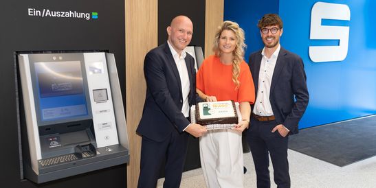 Bernhard Koppler, Key Account Manager Austria at KEBA; Janine Kohl-Peterke, Head of the Linz Central Region Market Area at Sparkasse Oberösterreich; and Philipp Katzenberger, Sales Director Austria and International at KEBA, holding a cake to mark the 10,000th cash recycler at Sparkasse Oberösterreich