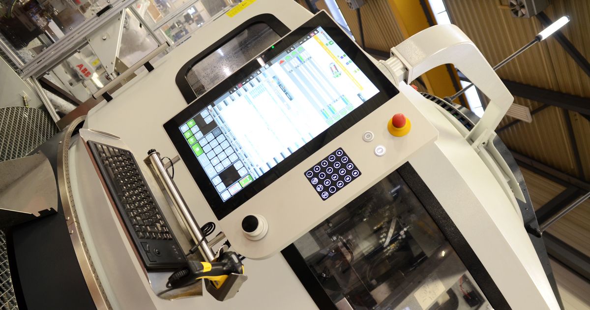 Modern HMI control panel with large touchscreen, emergency stop button, rotary knob, and integrated keyboard on an automated machine tool. The image represents intuitive machine operation and connected control technology in industrial automation.