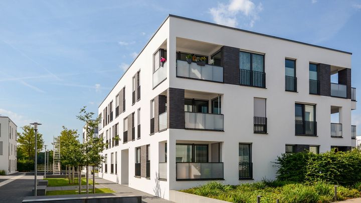 Modern apartment building with a landscaped entrance area.