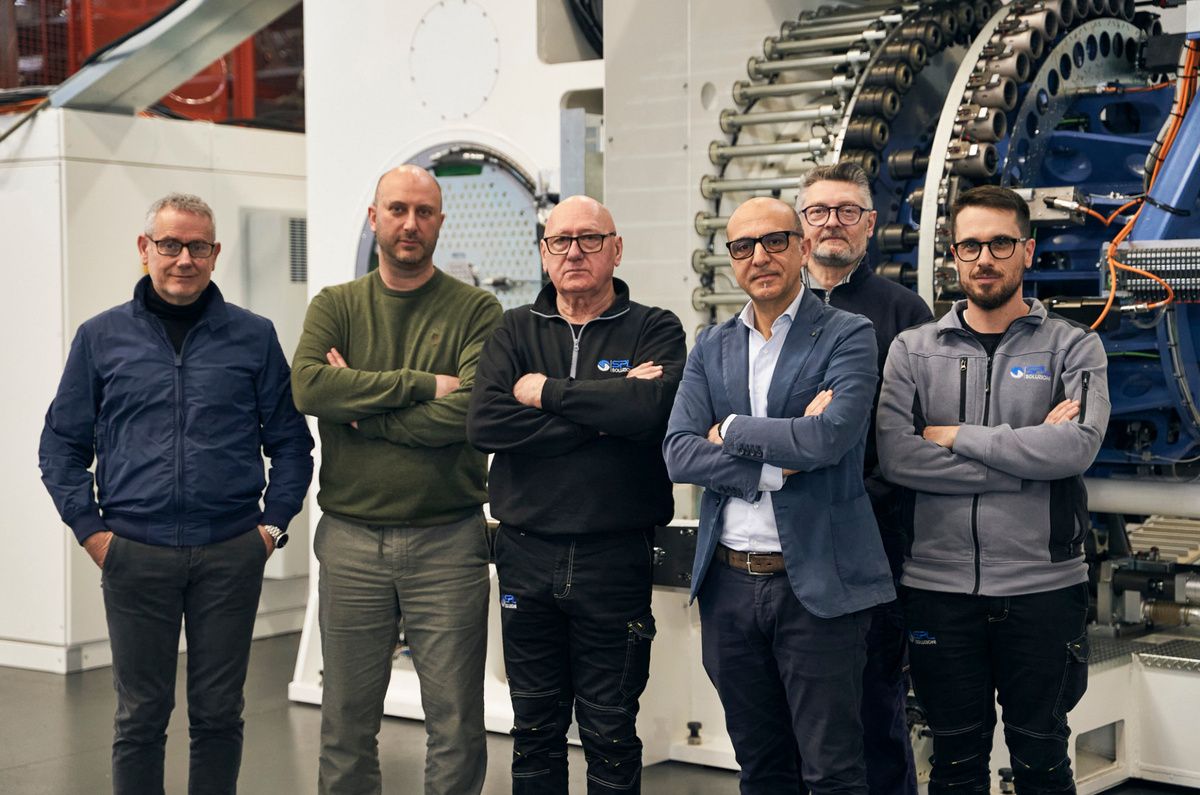 Employees from SPL and KEBA are standing together in front of a large-scale production machine in the manufacturing hall. The group photo highlights the strong partnership and technological expertise behind the development of innovative automation and control solutions. 