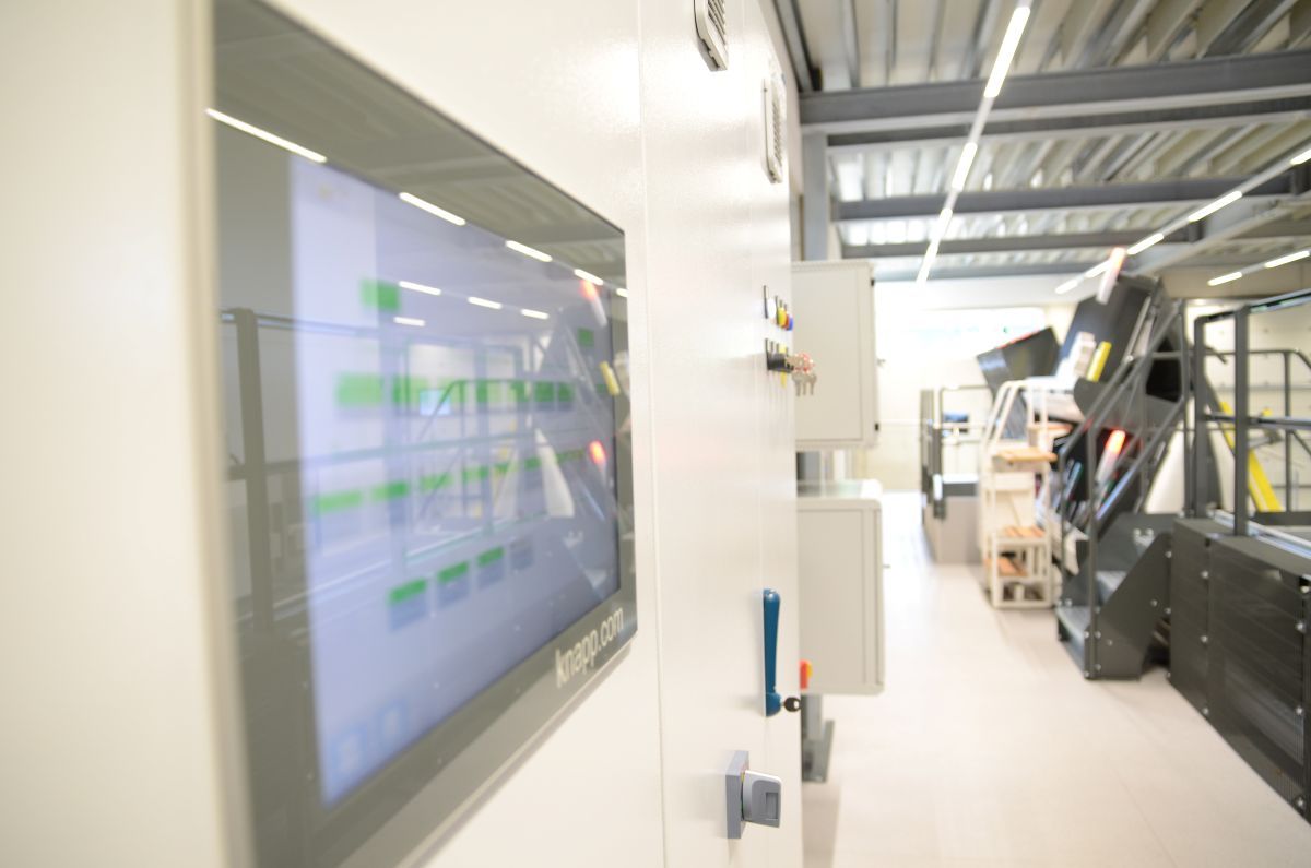 KEBA HMI solution in the field of pallet conveyor technology with digital display, with machines in the background.