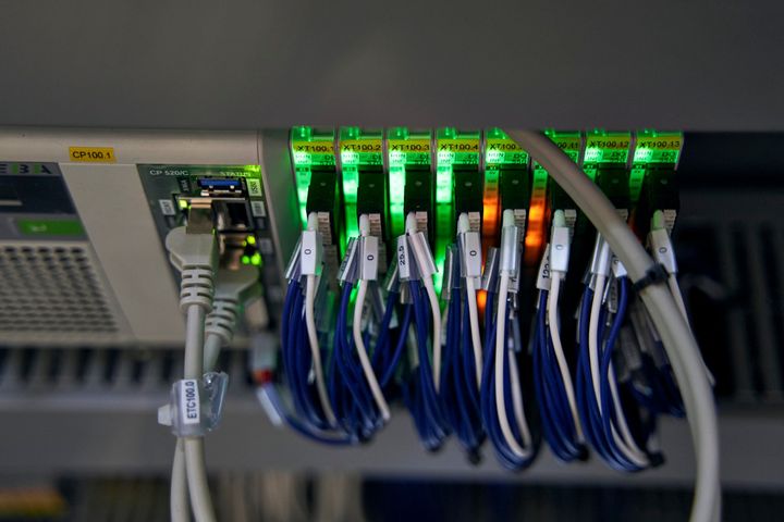 Network and control modules with connected communication cables inside an industrial control cabinet of an SPL production system. The components enable real-time communication and precise synchronization of machine axes and automation processes 