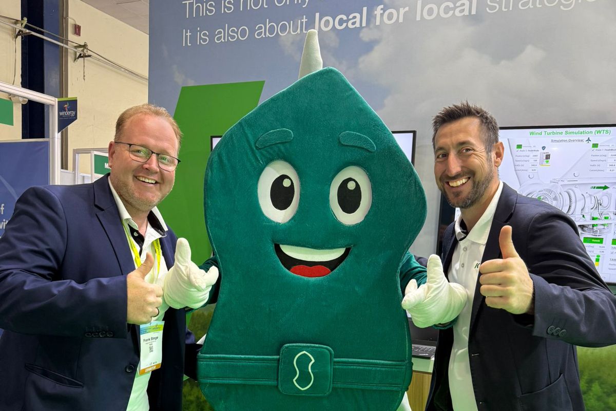 KEBA representative smiling and posing with the trade fair mascot.