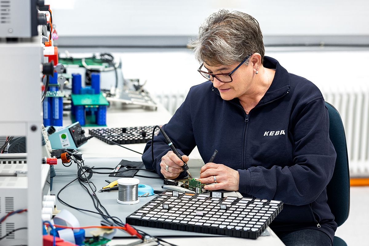 Eine KEBA-Mitarbeiterin arbeitet konzentriert an der Lötstation – Präzision und Technik im Einsatz für innovative Elektroniklösungen.