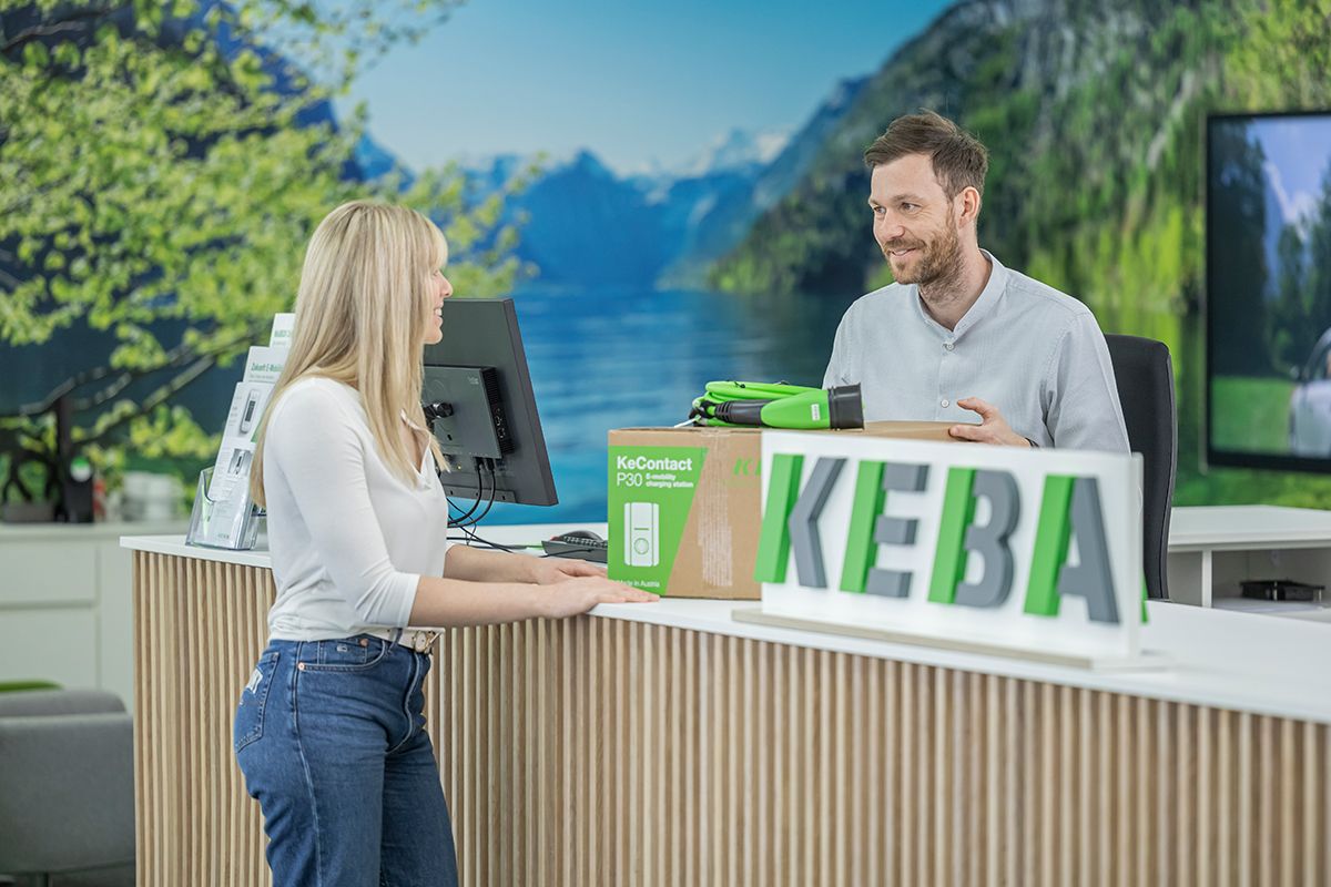 Employee advising a customer at the store counter.