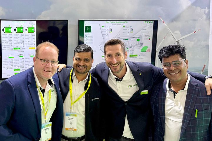 Four KEBA team members smiling and puting their arms around each other's shoulders 