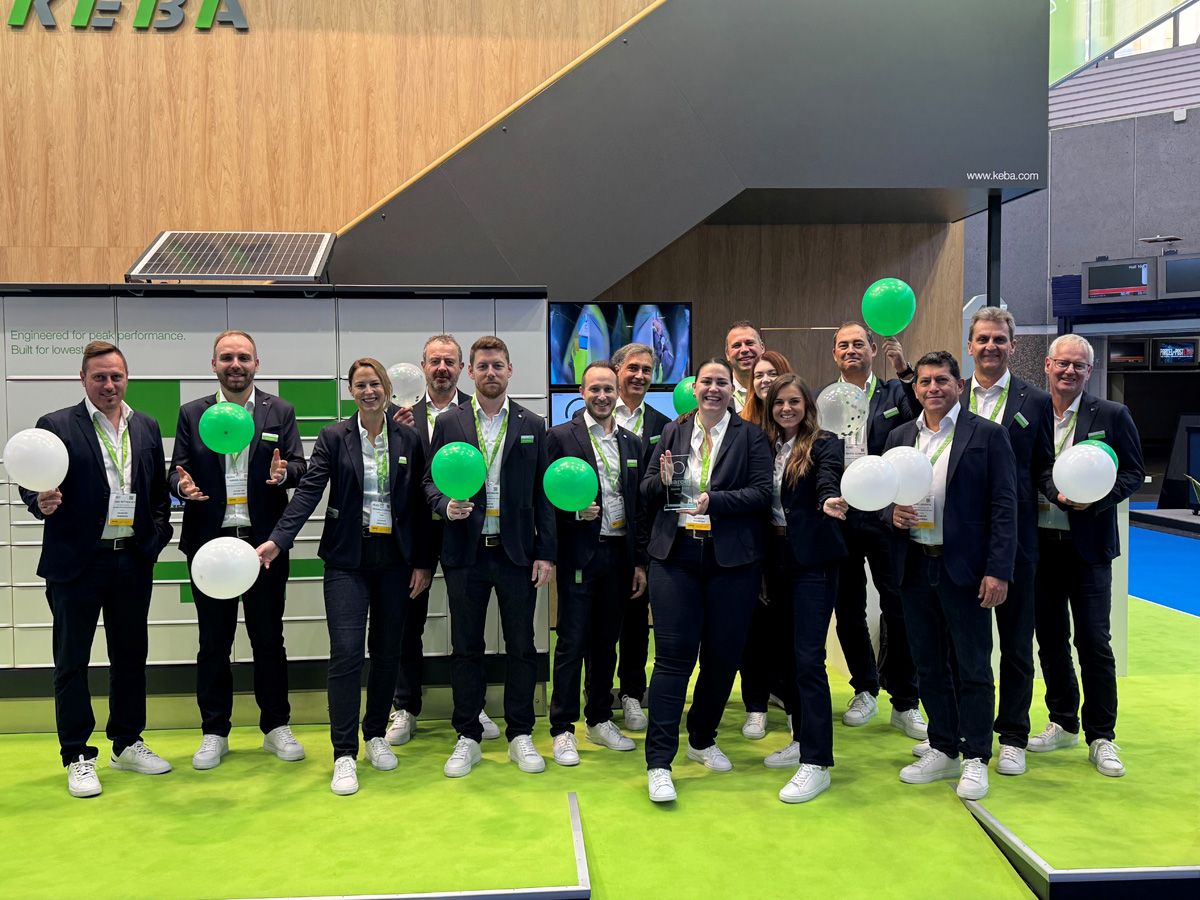 KEBA employees in matching outfits holding green and white balloons @ Parcel + Post Expo 2025
