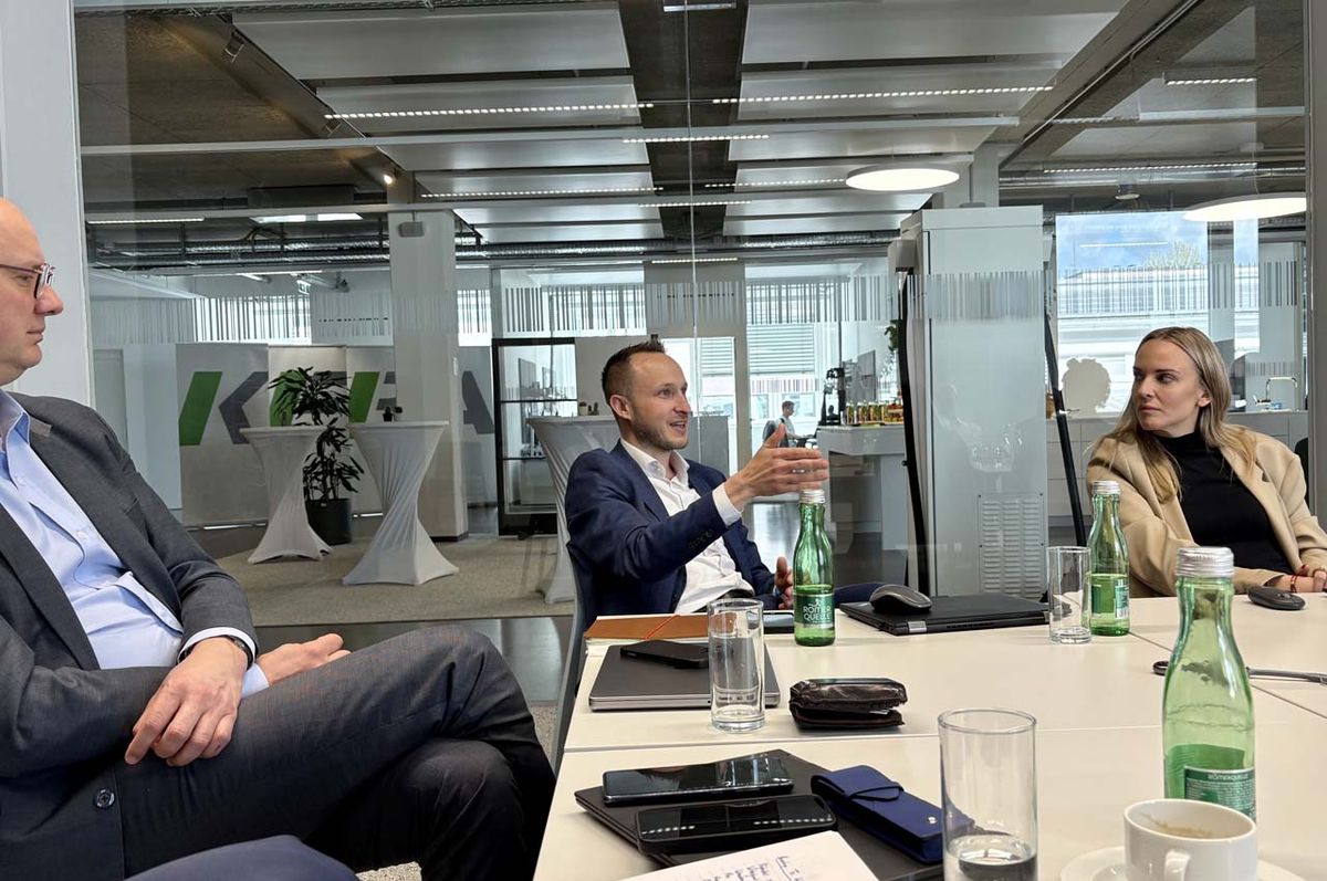 Patrick Gojer, CSO of KEBA Handover Automation GmbH, speaks with raised hand during a discussion at the Open Innovation Exchange at KEBA.